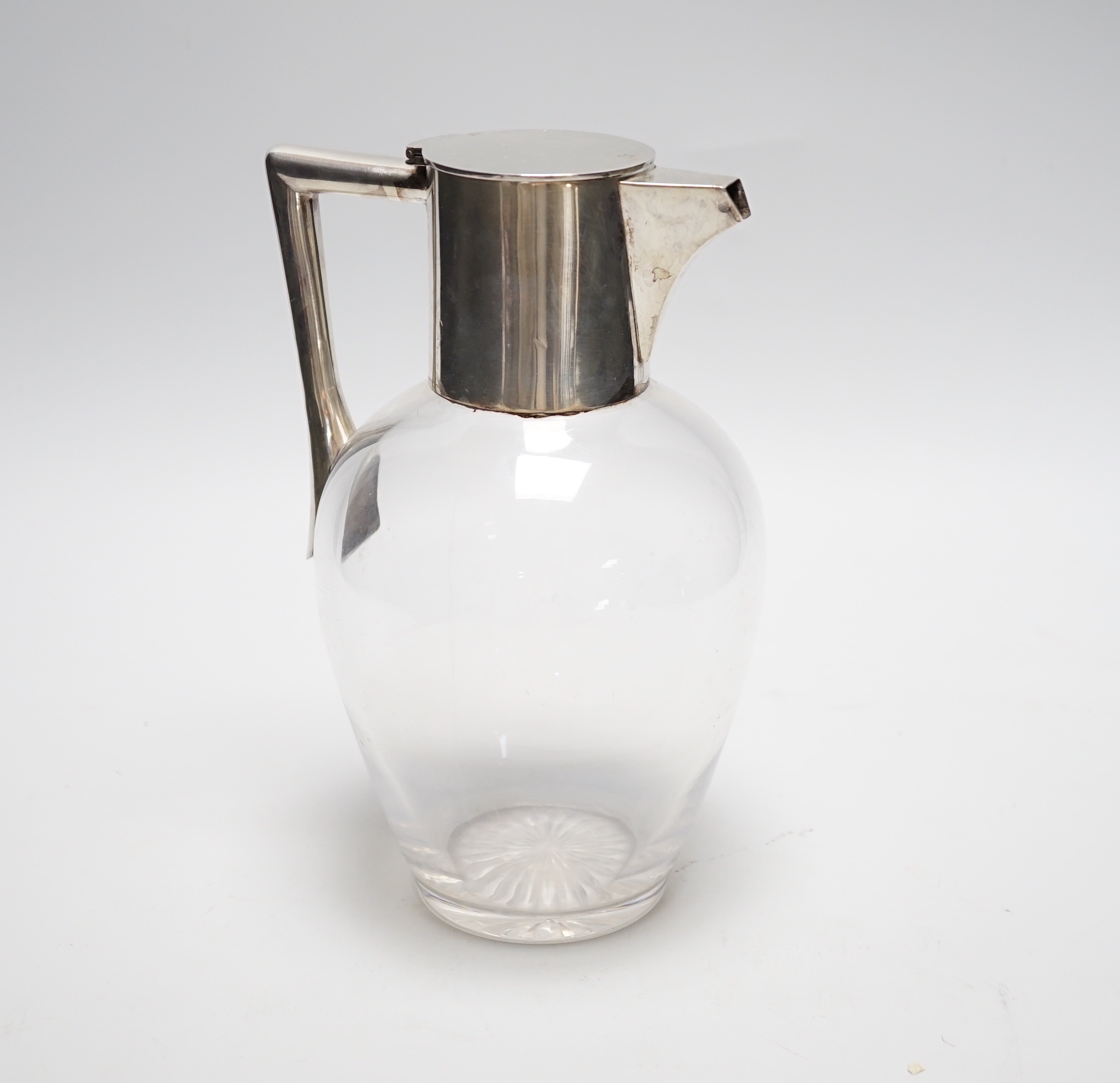 An Edwardian silver mounted glass claret jug, in the manner of Christopher Dresser, Goldsmiths & Silversmiths Co Ltd, London, 1909, 19.5cm.